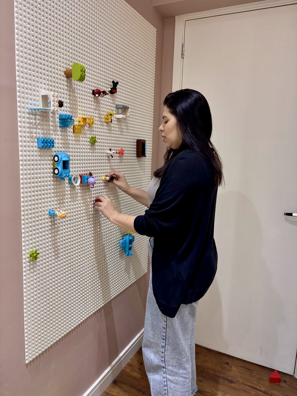 Thais Serafim montando peças na parede de pinos de uma sala do IDA