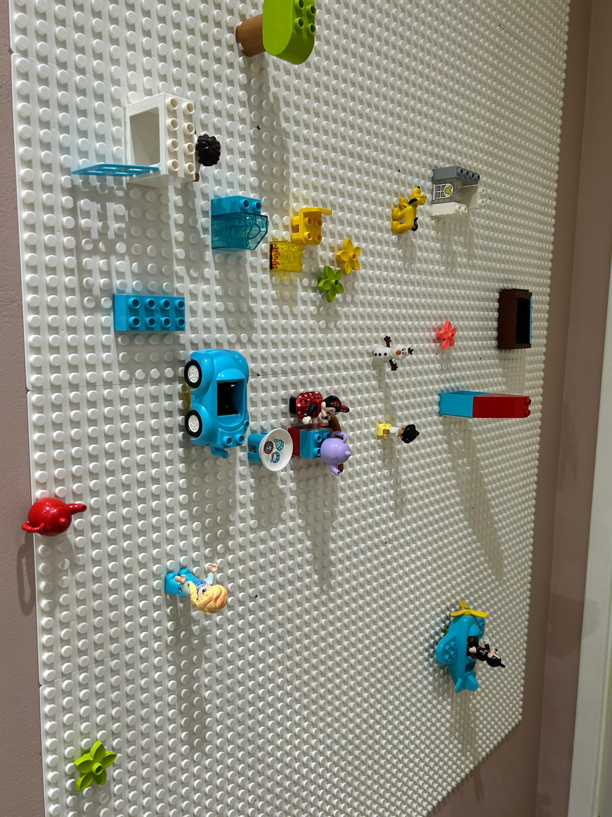 Parede de pinos com peças coloridas numa sala do IDA, nos Jardins