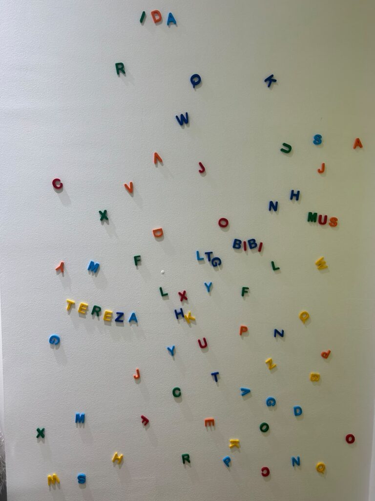 Parede de pinos com peças coloridas numa sala do IDA, nos Jardins
